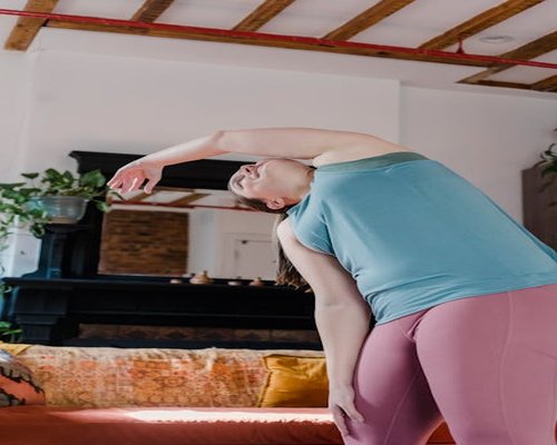 Person stretching gently in a living room with natural light